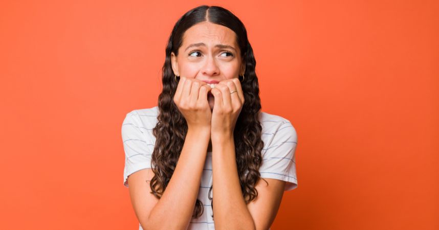 Smiling woman with hands on face, expressing comfort and relaxation, in a warm, inviting environment, related to managing dental anxiety and promoting a positive dental experience.