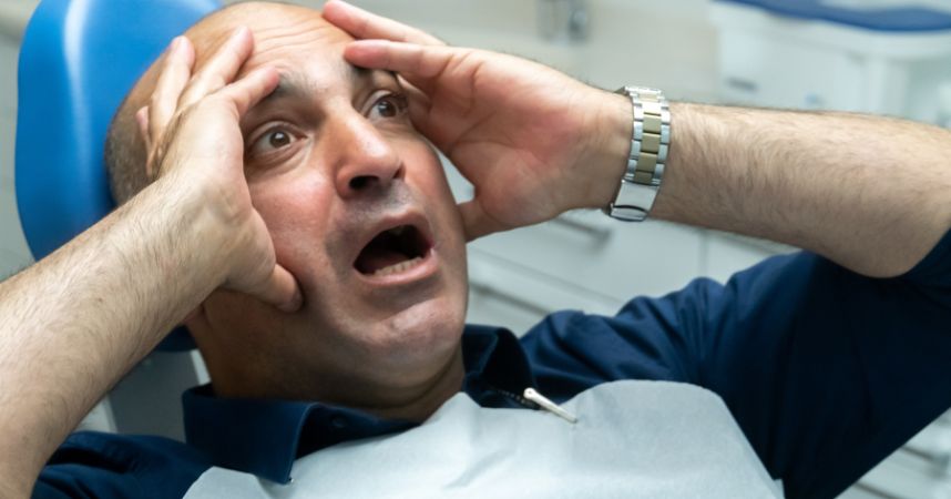Person covering their mouth with hands, expressing anxiety about dental visit, reflecting themes of dental anxiety and comfort at Dental Krafts.