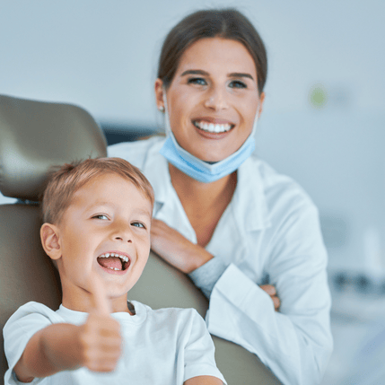Child smiling at the dentist, promoting positive dental experiences and encouraging regular dental visits for children's oral health.