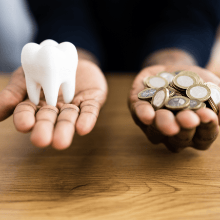 Hands holding dental implants and traditional dentures, illustrating options for full mouth dental restoration.