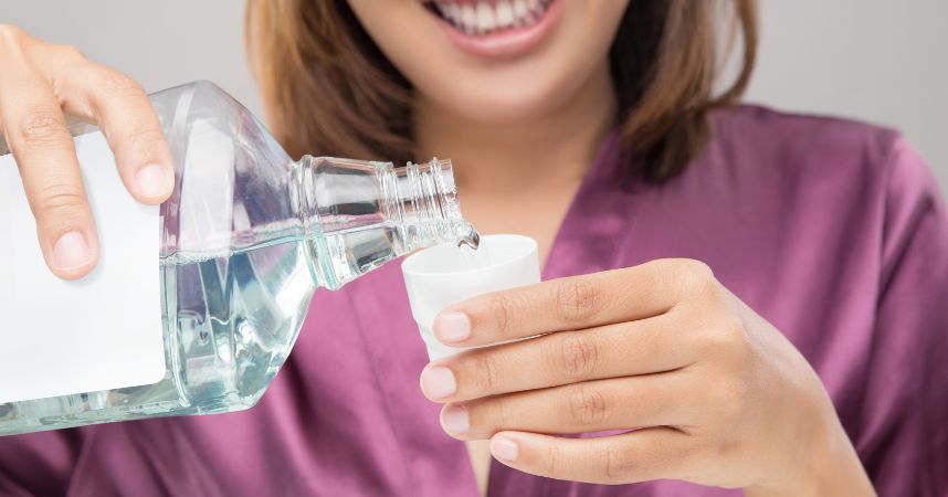 women pouring mouthwash in a glass