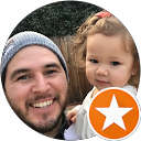 Smiling man holding a toddler, representing family-friendly dental care at Dental Krafts, highlighting positive patient experiences.